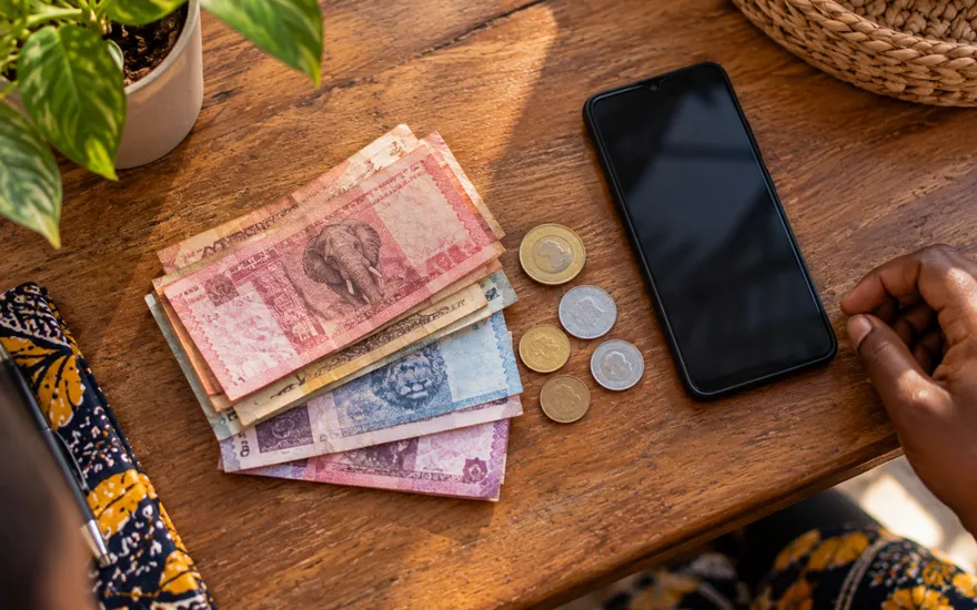 Small Tanzanian shilling notes and coins set aside for a minimum betting deposit